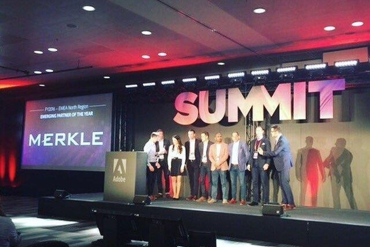 A group on stage at Adobe Summit, with Merkle and Emerging Partner of the Year on the screen behind them.